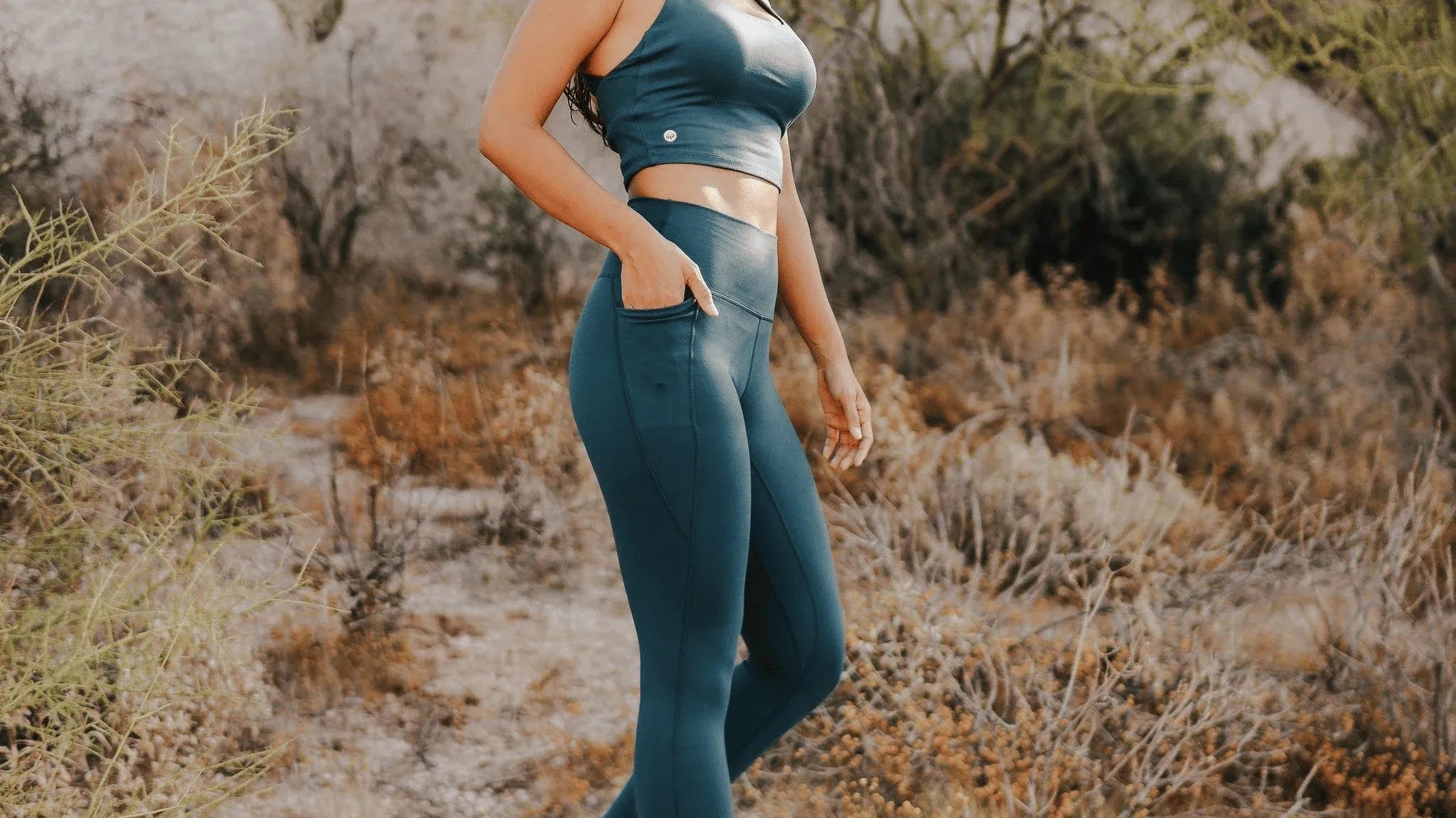 Woman wearing Skin Shakti Leggings (27 in. inseam) - Pacific with desert scenery in the background