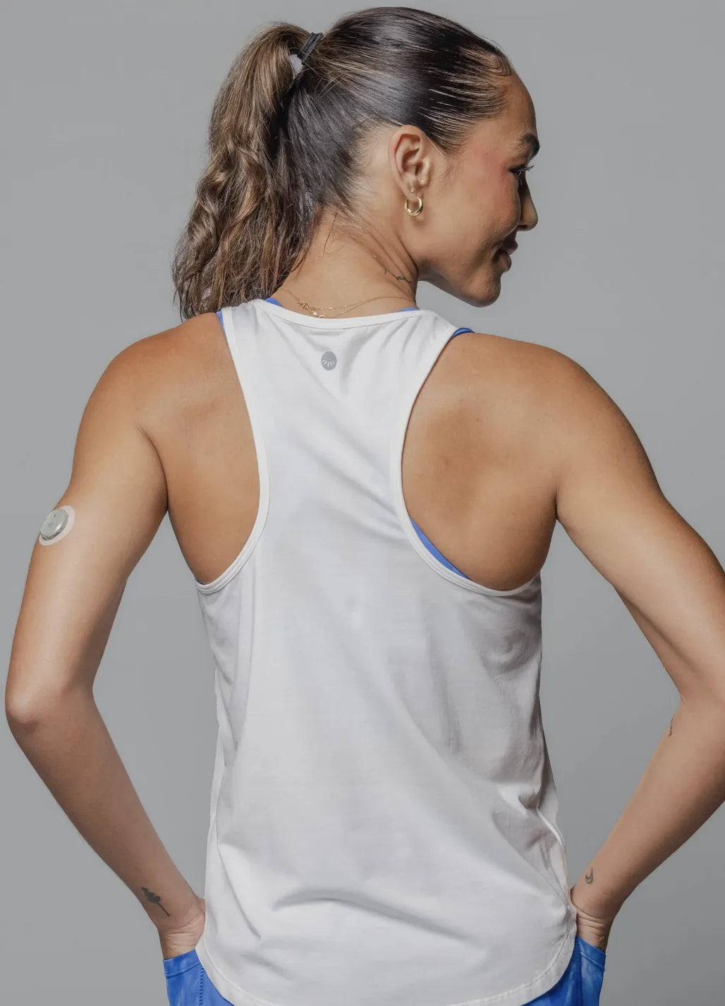 Back view of woman wearing Everyday Tank - White with blue leggings